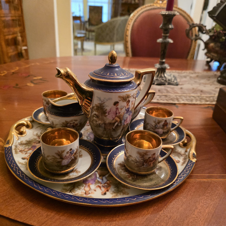 Porcelain tea set with cobalt blue and gold decoration featuring romantic pastoral scenes