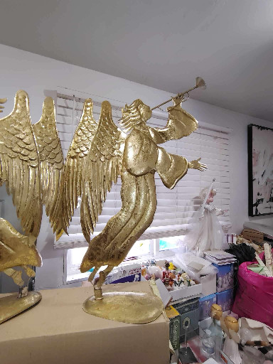 Gold-painted metal sculpture of Angel Gabriel with trumpet