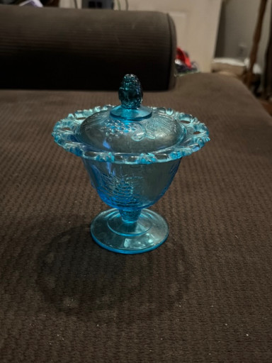 Blue pressed glass covered candy dish with lace edge in 'Harvest Grape' pattern by Indiana Glass
