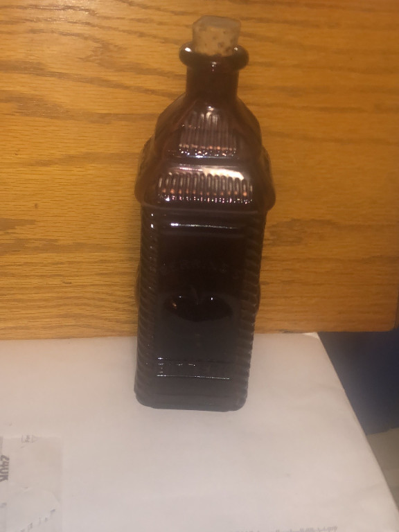 Reproduction amethyst glass bottle titled 'Berring's Apple Bitters' by Wheaton Glass
