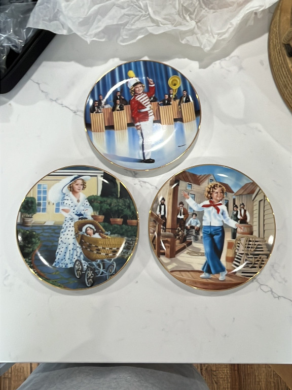 Porcelain collector plates from the Danbury Mint Shirley Temple Collection, featuring scenes from 'Poor Little Rich Girl' and other films