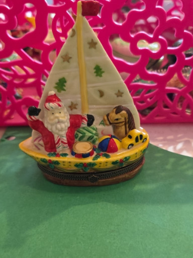 Hand-blown glass Christmas ornament depicting Santa in a sailboat