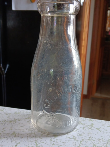 Pint-size embossed glass milk bottle from Uncle Sam's Dairy Farm by E. J. Parry