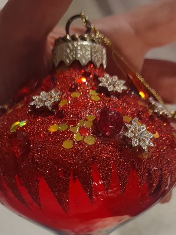 Glass Christmas ornament with customized embellishments including glitter, sequins, and jewelry elements