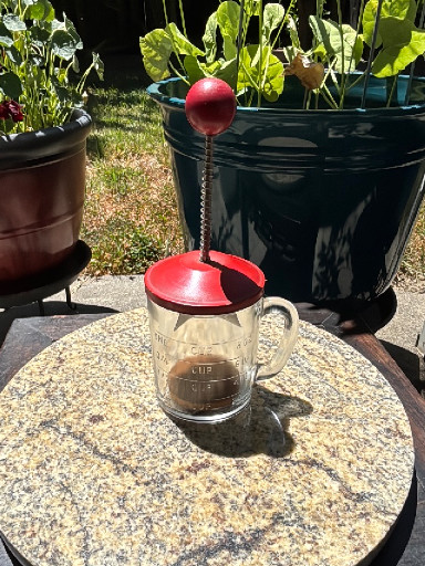 Glass and metal hand-operated nut chopper with red painted metal lid and knob, circa 1950s