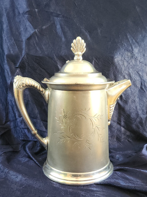 Silver-plated coffee pot with shell finial and engraved floral design. MFG. by Van Bergh Co. Quadruple plate.
