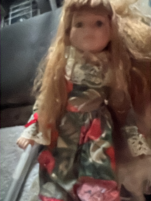 Porcelain-headed doll with fabric body and floral dress