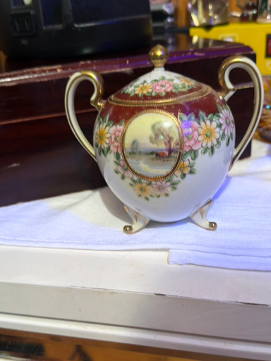 Porcelain covered sugar bowl with hand-painted floral decoration and scenic cartouche