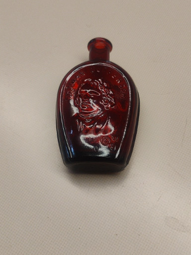 Ruby red glass miniature bottle with embossed portrait of Thomas Jefferson by Wheaton Glass Company