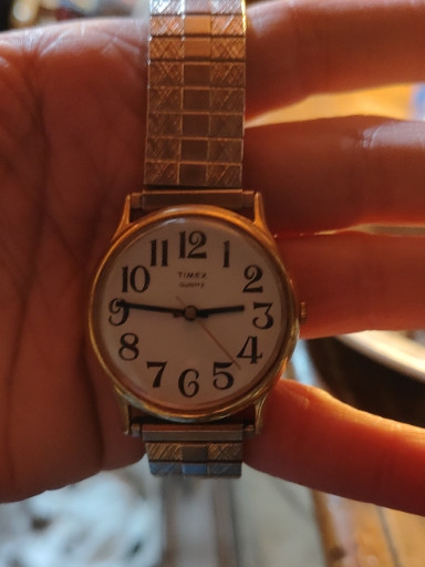 Vintage Timex quartz analog wristwatch with gold-tone case and expansion band