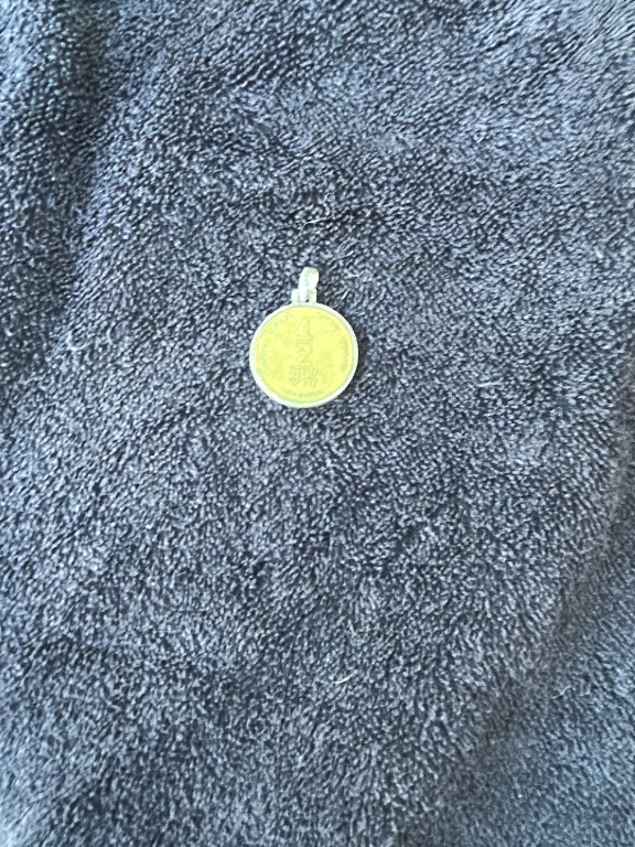 Gold-tone religious medal pendant, likely depicting a saint or religious figure