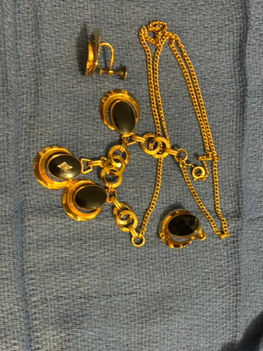 Vintage gold-tone jewelry set with black cabochon accents, including necklace, bracelet, and earrings