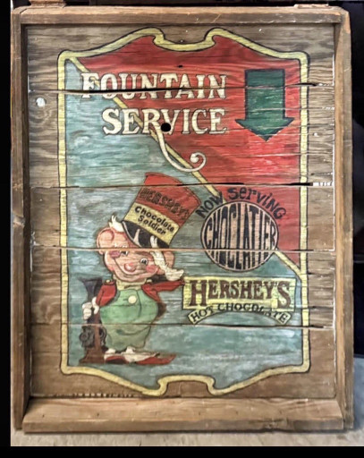 Wooden advertising sign for Hershey's Chocolate featuring 'Fountain Service' with vintage character illustration