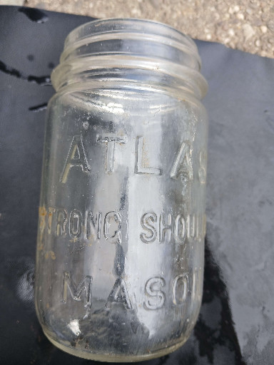 Clear glass canning jar titled 'Atlas Strong Shoulder Mason'