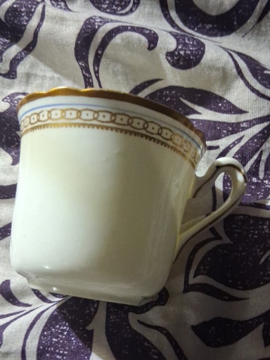 Porcelain teacup with gold trim and decorative banding. Grosvenor China.