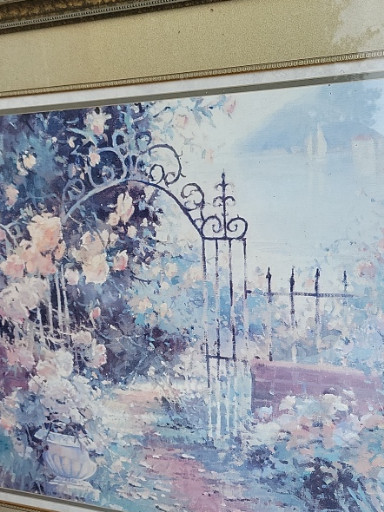 Framed print depicting an impressionistic garden courtyard with archway and seaside view