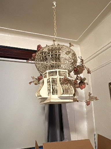 Decorative metal birdcage in hot air balloon shape with ornate filigree dome and floral accents