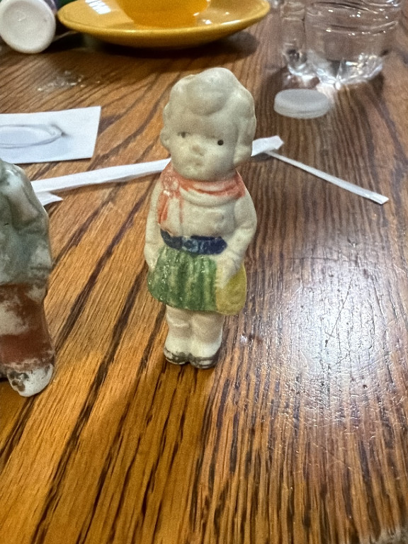 Bisque porcelain figurine of a young girl holding a purse