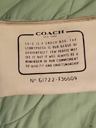 Leather wristlet/clutch titled 'Storypatch Creed' by Coach