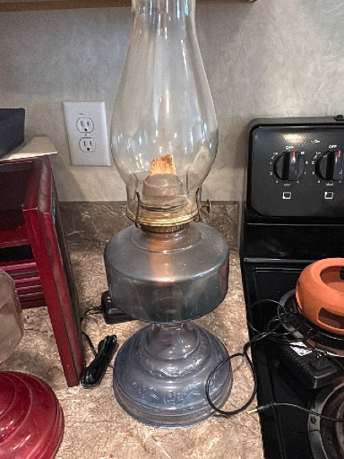 Vintage glass kerosene oil lamp with metal base and clear glass chimney