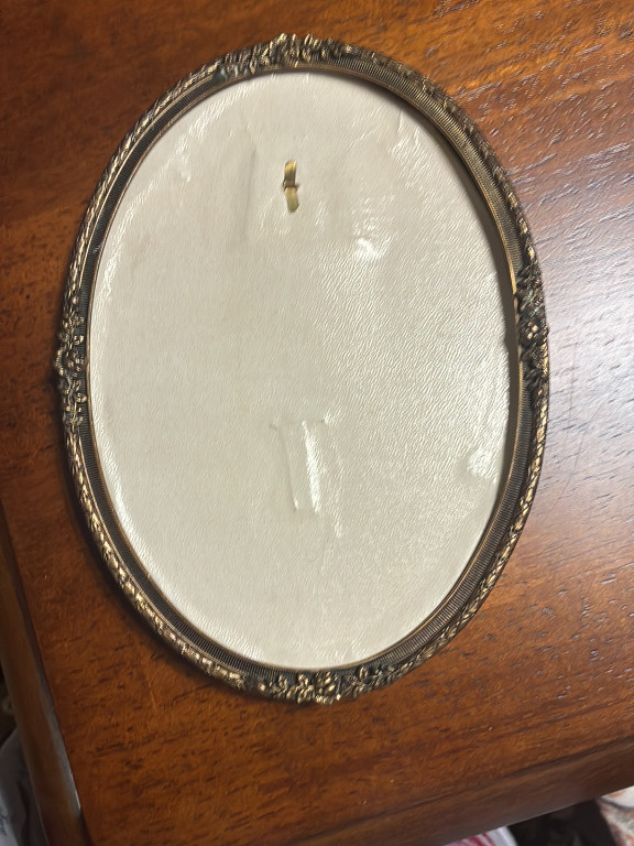 Ornate oval picture frame with decorative metal border