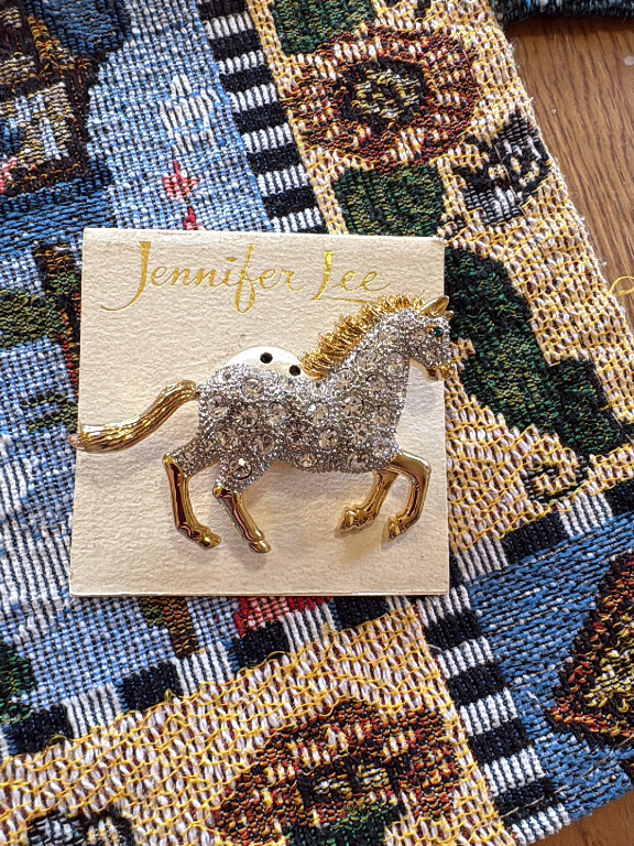 Costume jewelry horse brooch by Jennifer Lee, gold-tone metal with clear rhinestones