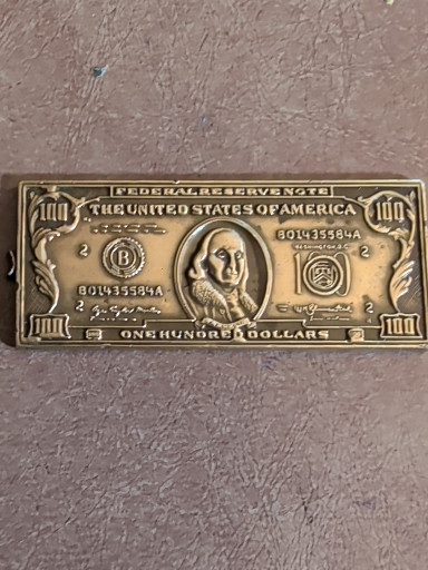 Brass commemorative bar depicting a $100 Federal Reserve Note with Benjamin Franklin