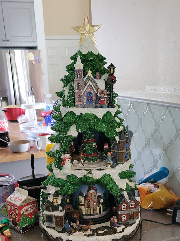 Illuminated Christmas village tree decoration with miniature buildings and figurines