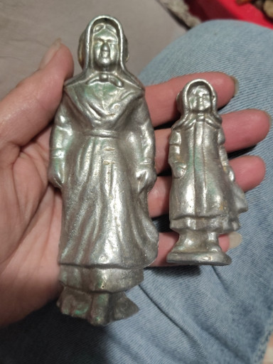 Cast metal figurines depicting Amish woman and child
