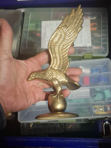 Brass eagle sculpture perched on a globe with wooden base