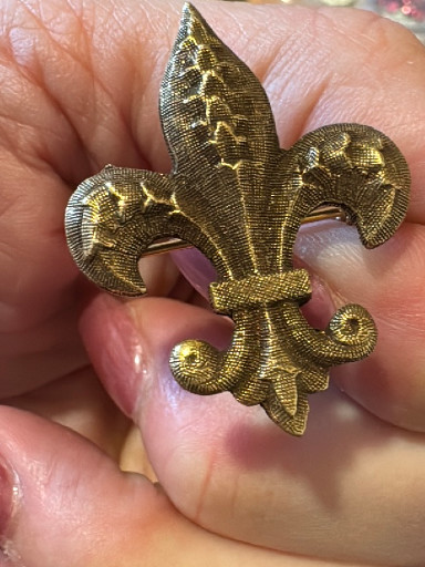 Gold-tone metal fleur-de-lis brooch with textured detailing