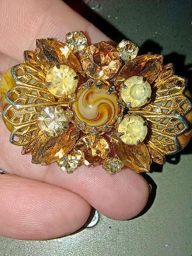 Gold-tone metal brooch with amber rhinestones and molded glass center, mid-20th century costume jewelry