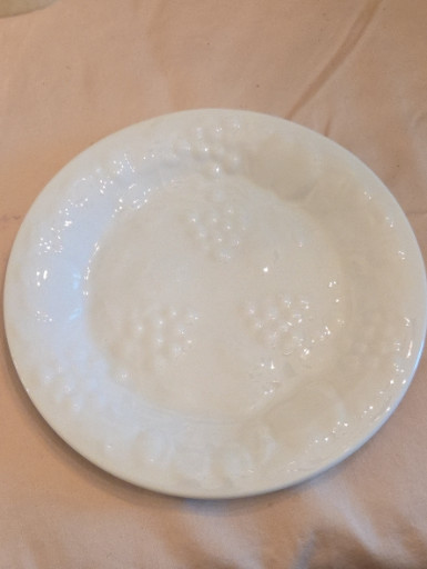 White ceramic salad plate with embossed fruit design by Gibson Designs