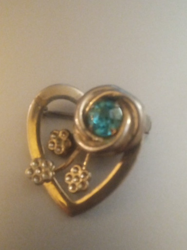 Gold-tone brooch with blue rhinestone and floral motifs