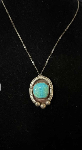 Sterling silver pendant necklace with turquoise or opal-like stone and decorative metalwork