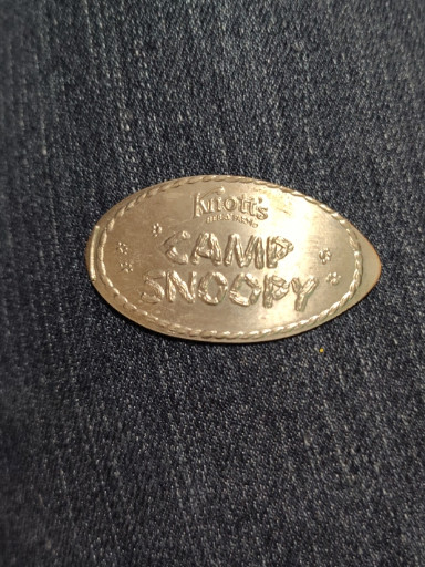Brass arcade token from 'Knott's Camp Snoopy' dated 1996