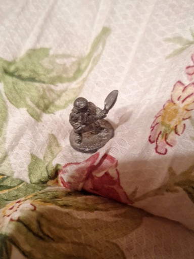 Pewter miniature figurine depicting a warrior or character with helmet and weapon