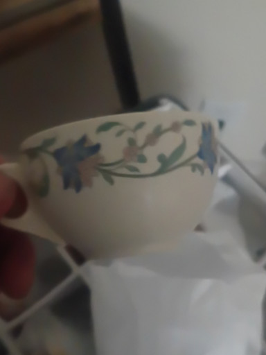 Porcelain teacup with blue floral vine and ribbon decoration