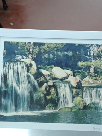 Watercolor painting depicting a cascading waterfall landscape, signed by Carrie Sloan