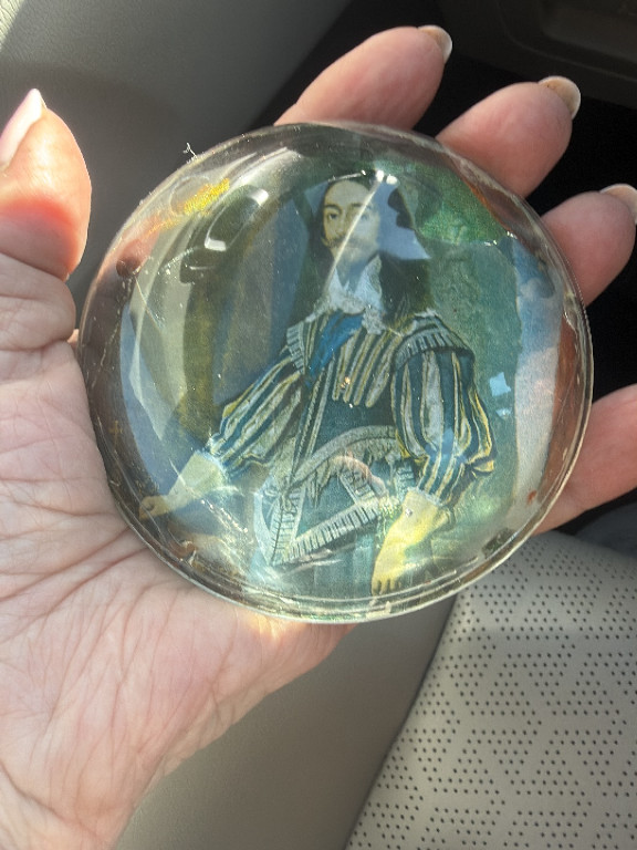 Glass paperweight featuring an encased portrait of a woman in blue robes by Daphne Pain