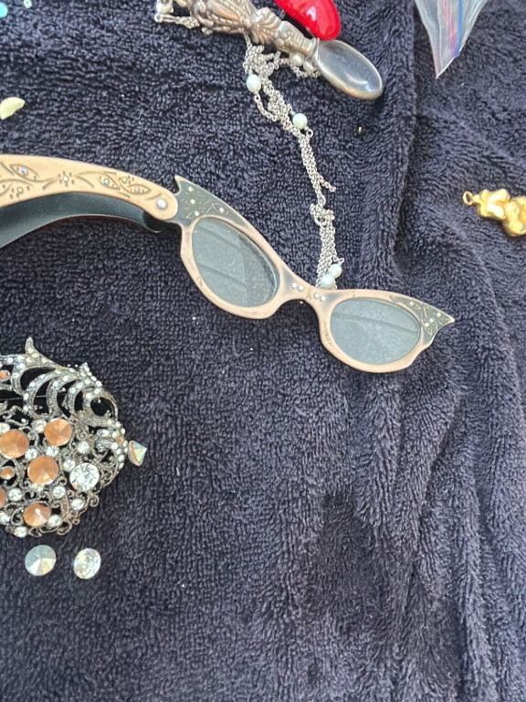 Vintage cat-eye eyeglasses with decorative metal frames and green-tinted lenses