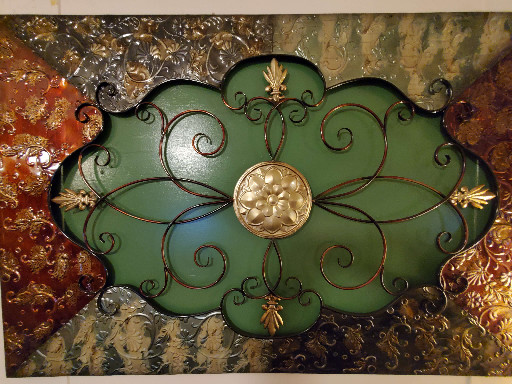 Metal wall decor with scrollwork and floral medallion