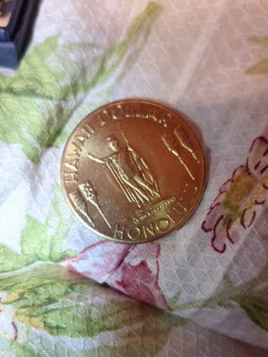 Brass souvenir token titled 'Hawaii Dollar Honolulu' from 1976