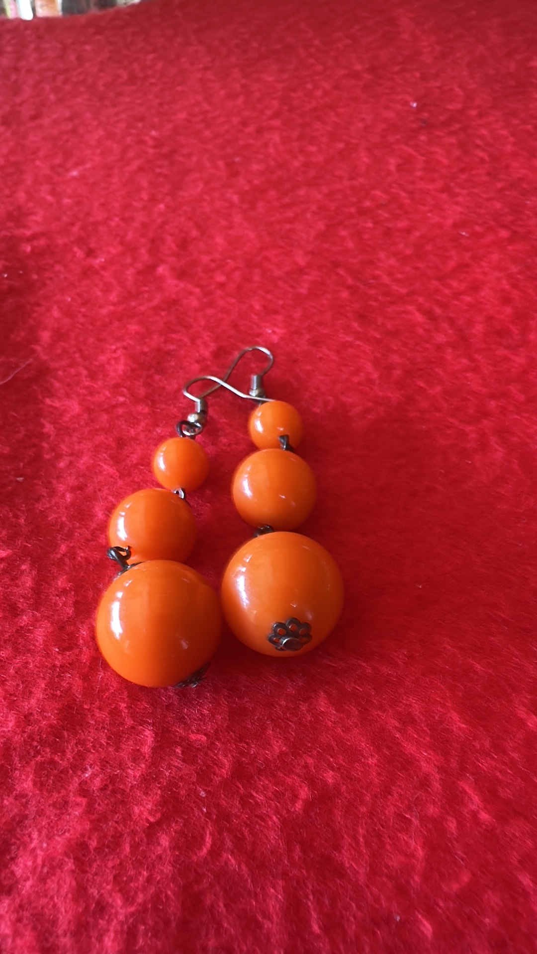 Plastic dangle earrings with orange beads