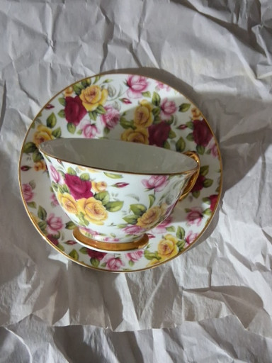 Fine bone china teacup and saucer with floral rose pattern and gold trim