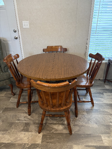 Solid oak round pedestal dining table with four Windsor-style spindle-back chairs