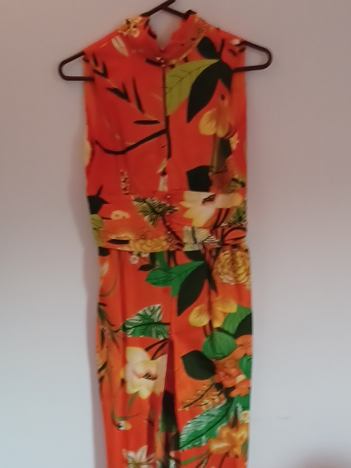 Vintage 1970s polyester halter jumpsuit with tropical floral print, front zipper slit, and peekaboo cutouts