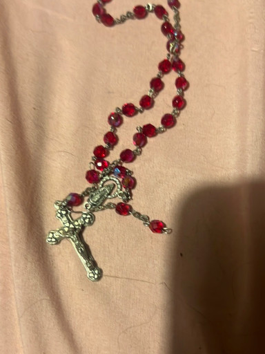 Red faceted glass rosary with silver-tone crucifix and center medallion