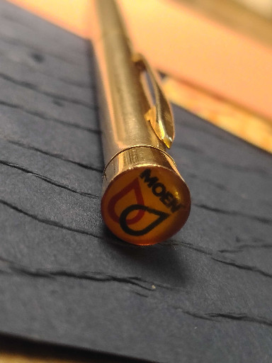 Gold-filled ballpoint pen with promotional cap emblem