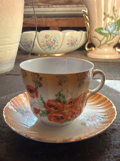 Porcelain teacup and saucer with hand-painted poppy floral decoration and gold trim